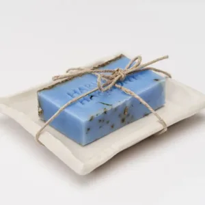 Blue lavender soap tied with rustic twine on a white dish.