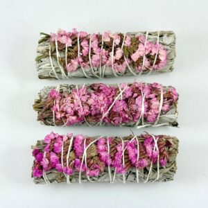 Three bundles of dried sage and pink flowers tied with white string.