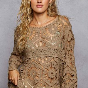 Woman wearing a beige crochet sweater with intricate patterns.