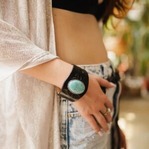 A person wearing a smartwatch and a light cardigan, with hand in pocket.
