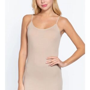 Woman in beige sleeveless dress with hand on hip.