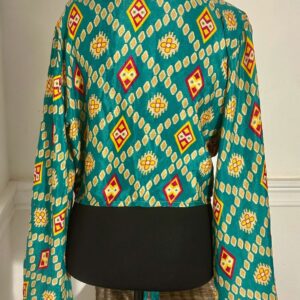 Turquoise and yellow patterned long-sleeve top with a black hem.