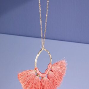 Elegant gold necklace with pink fan-shaped tassels on a purple background.