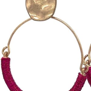 Close-up of a gold and red hoop earring.