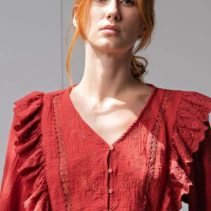 Woman wearing a red vintage-style blouse with ruffled shoulders.