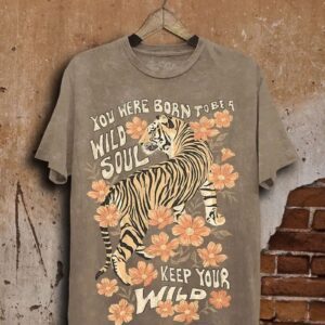 A beige t-shirt with a tiger and floral design, featuring the text about wild souls and keeping wild.