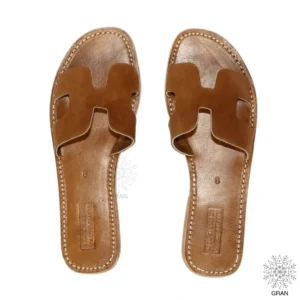 Pair of brown leather slip-on sandals with cut-out design.