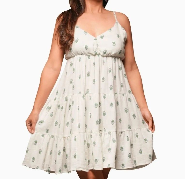 Woman wearing a white floral spaghetti strap dress.