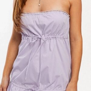 Woman wearing a strapless light purple dress with a cinched waist.