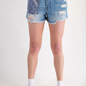 Person wearing distressed denim shorts and white socks, standing against a plain background.