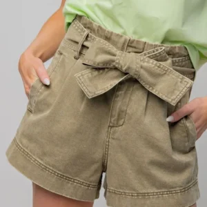 Close-up of khaki shorts with a tied fabric belt.
