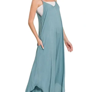 Woman wearing a loose, light blue sleeveless dress with pockets.
