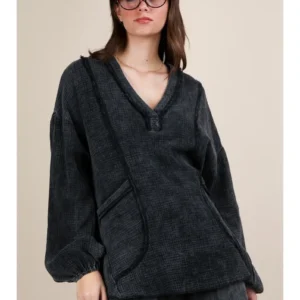 Woman wearing a cozy black fleece pullover with a front pocket and buttoned V-neck.